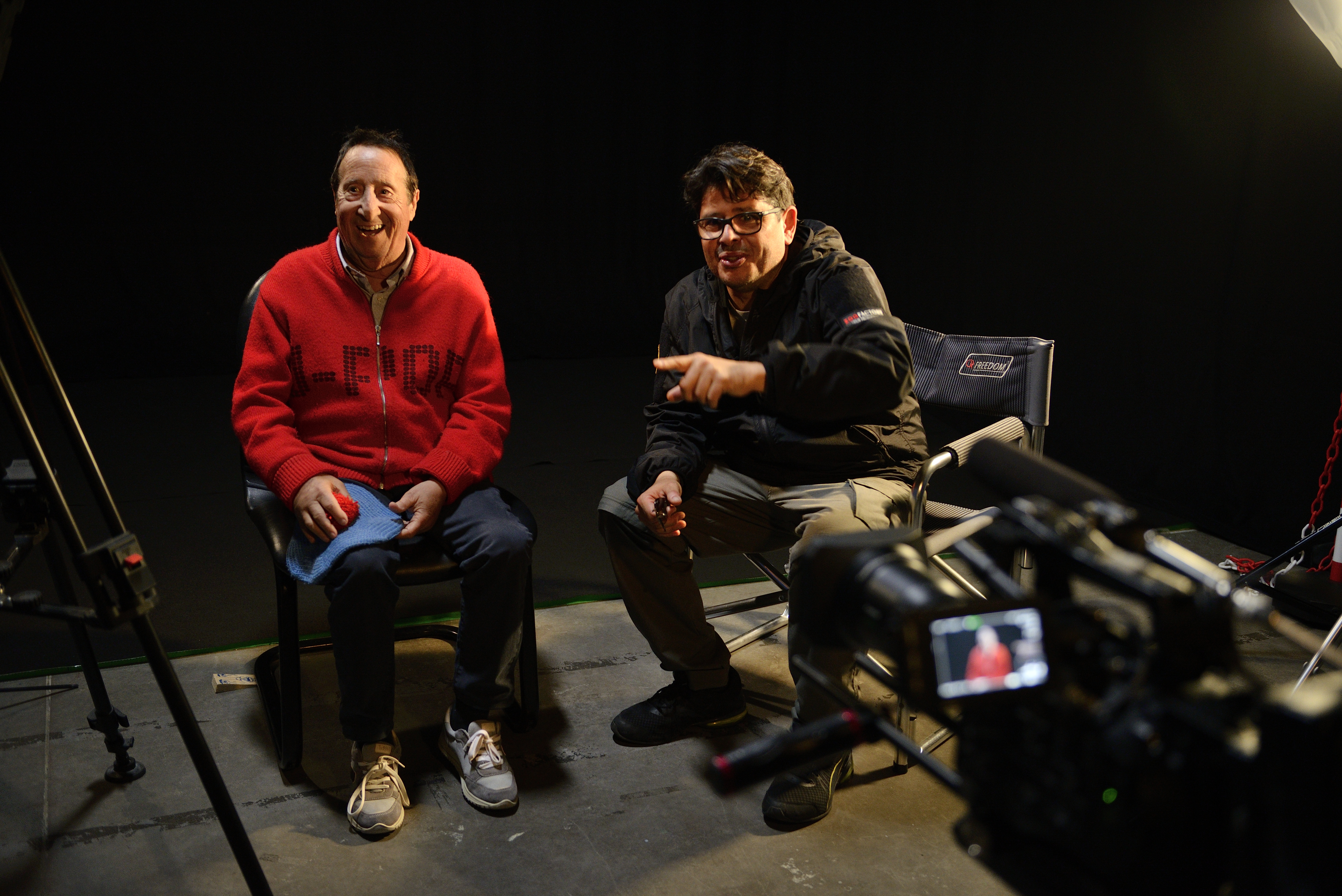 Due protagonisti sorridono sul set davanti alla telecamera